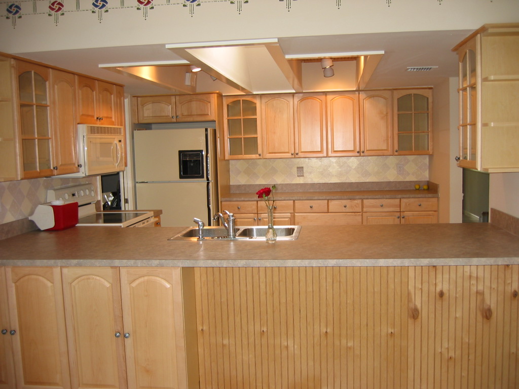 a kitchen with wood cabinets and a small sink