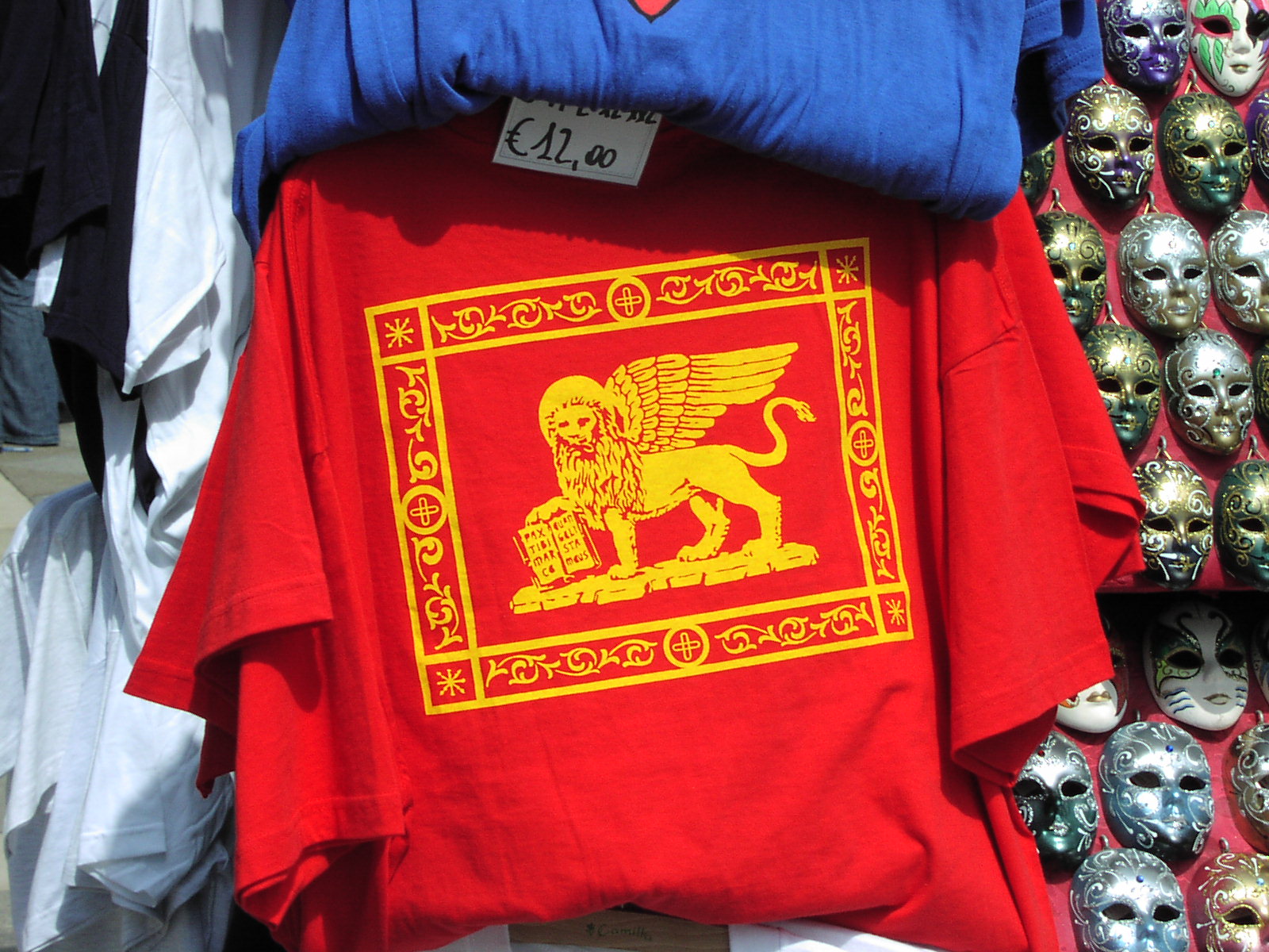 a red t shirt with a gold lion and winged winged creature printed on it