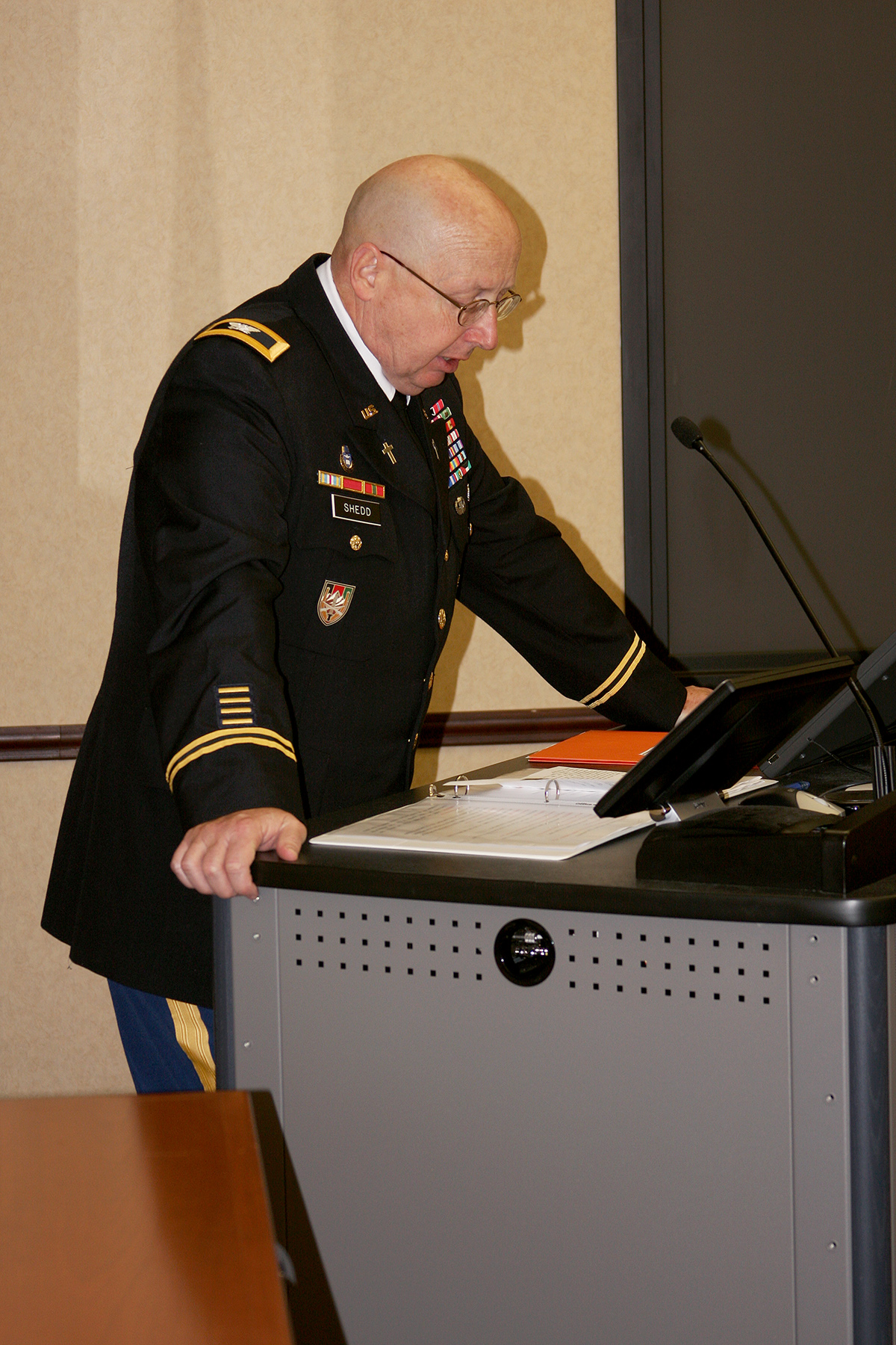 man in military dress suit looking over a desk