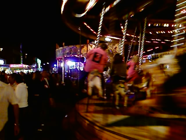 people walking around in a carnival park at night