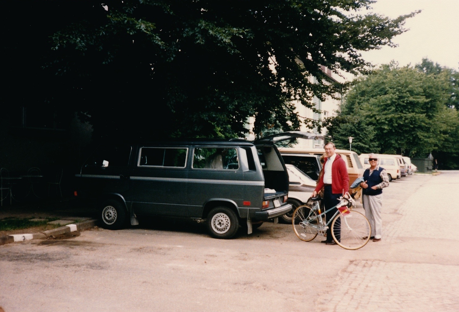 man on a bike next to a van and van with the driver standing next to it