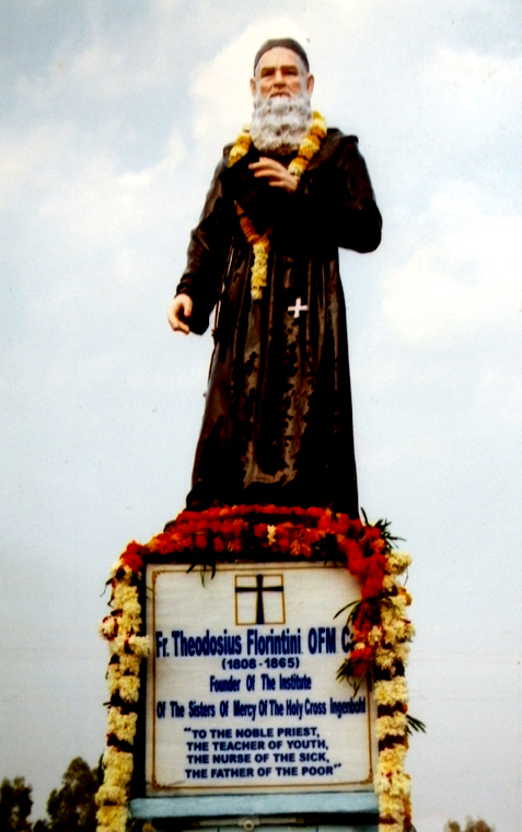 a statue of a priest is shown near a sign