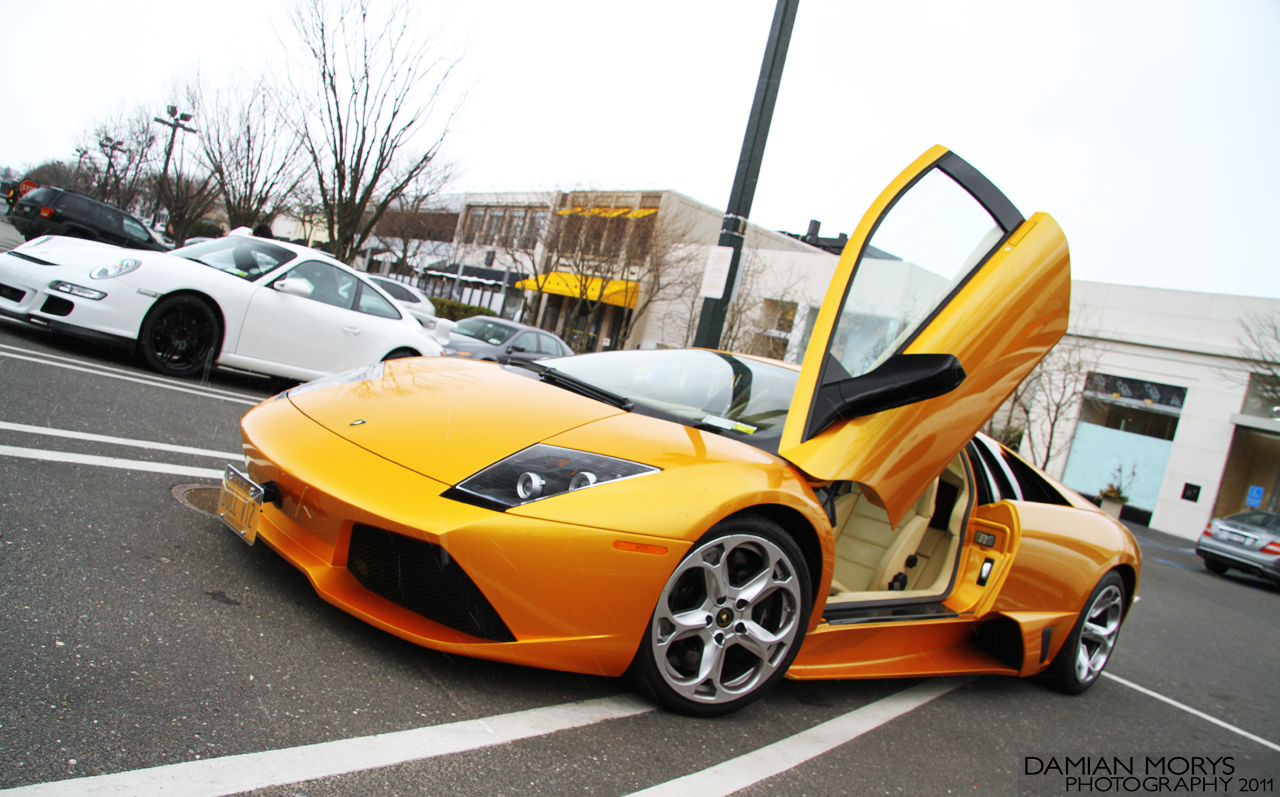 a yellow sports car is parked in the street