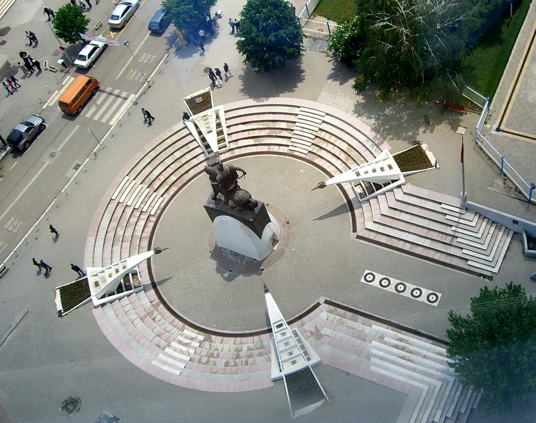 a view from the top of a building shows a circular space with benches