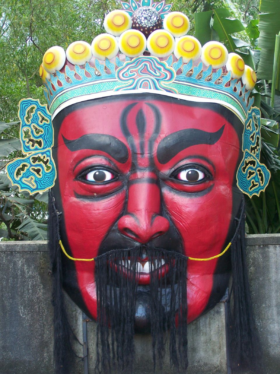 a big red mask with a beard wearing a crown
