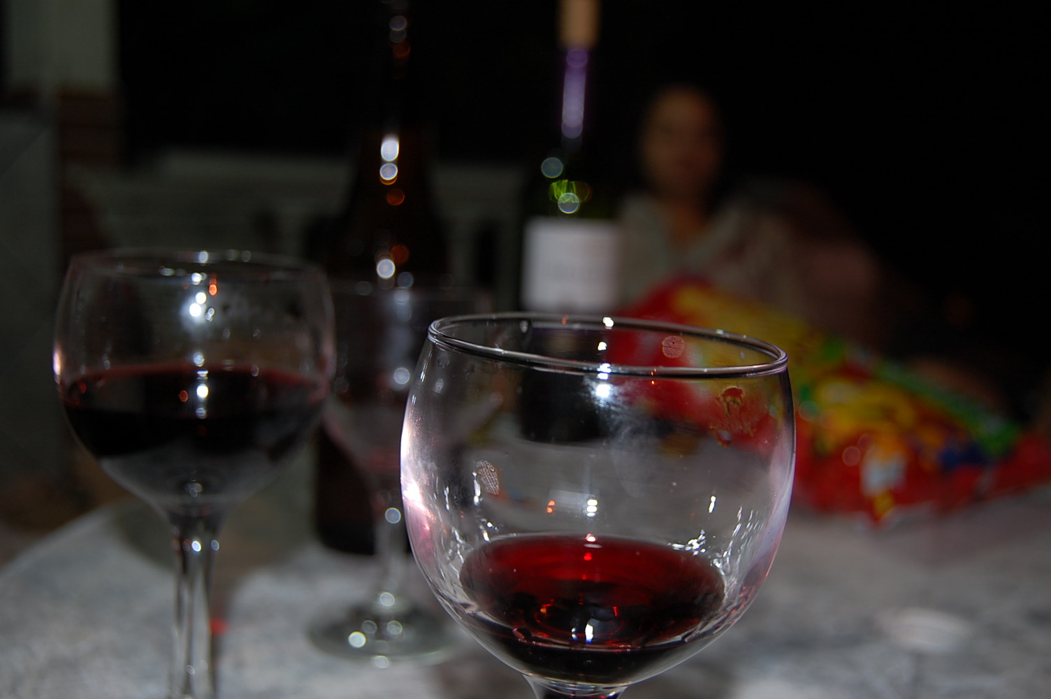 a glass of red wine next to a partially filled glass of red wine