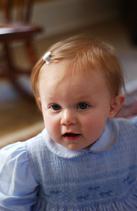 a small baby wearing a blue dress