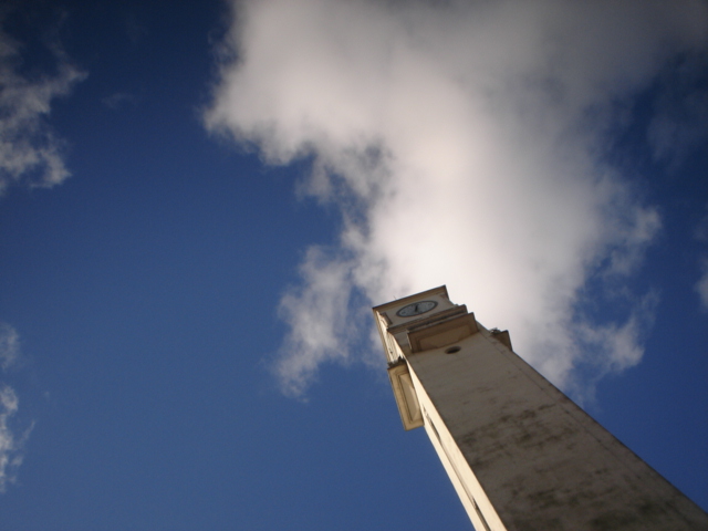 clock tower from below with clouds in sky