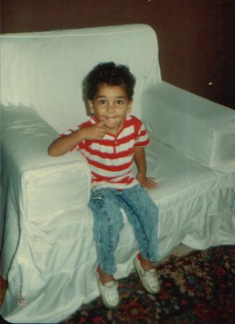 small child in striped shirt sitting on white couch