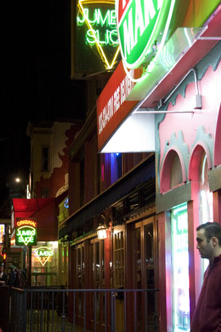 a man walks past a restaurant during the night