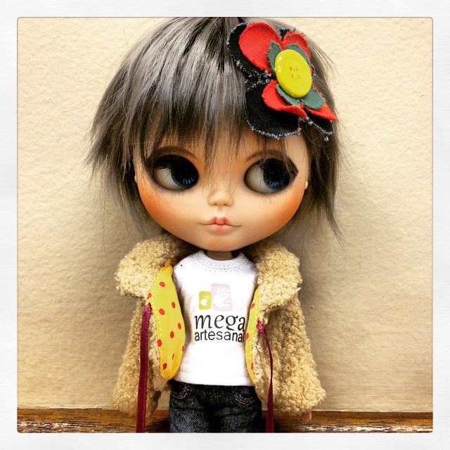a small doll wearing a vest and jacket