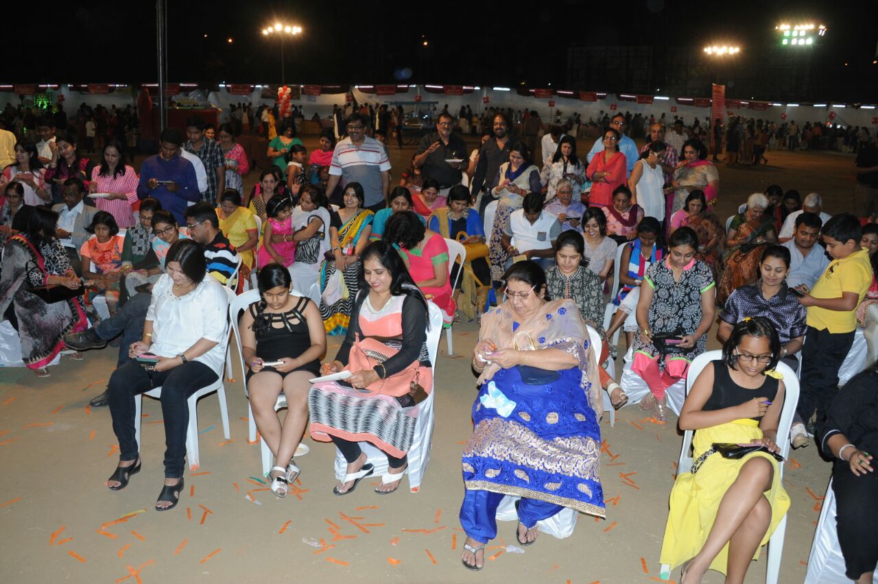 people seated in chairs in a large crowd