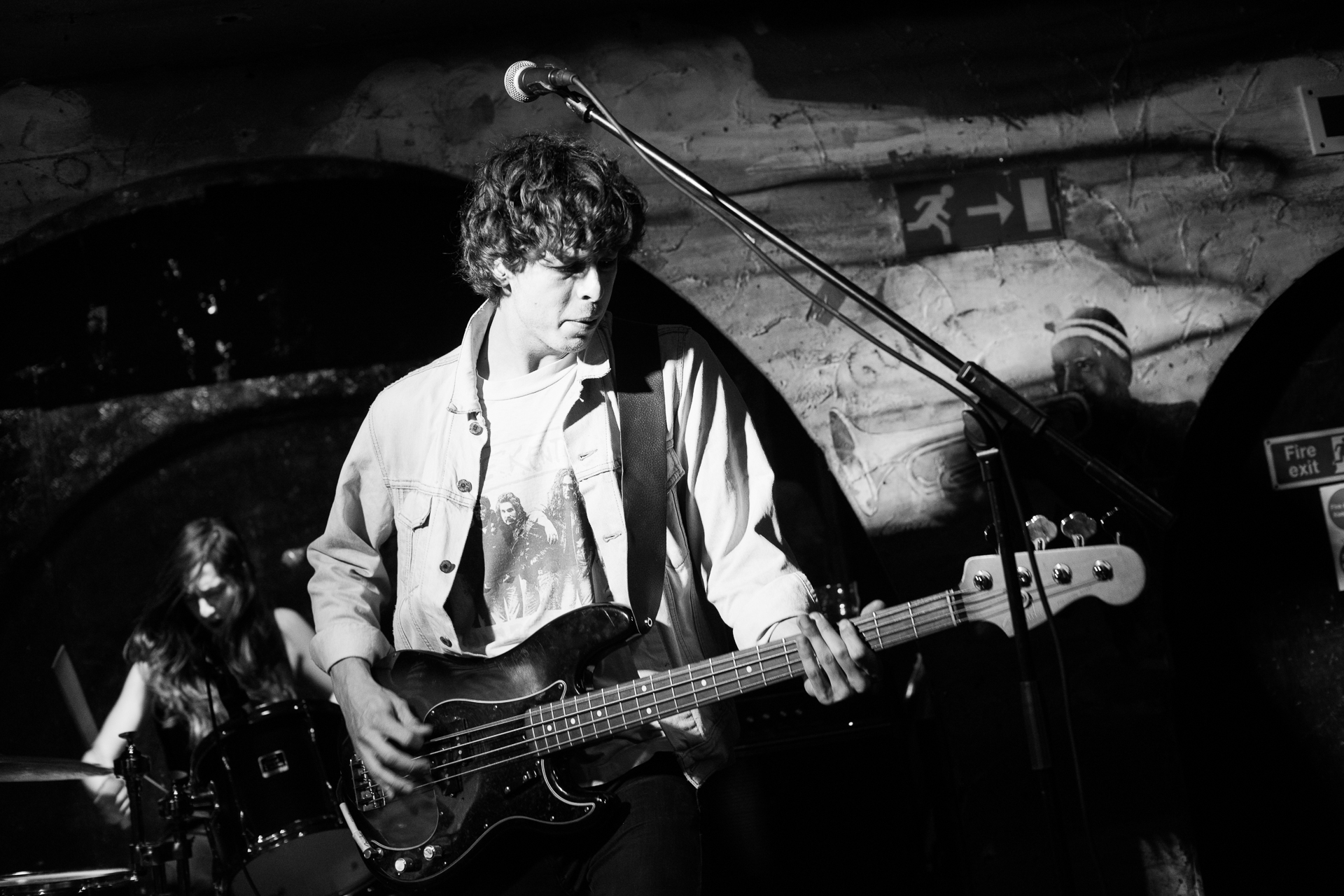 the young man is playing his bass in front of a microphone