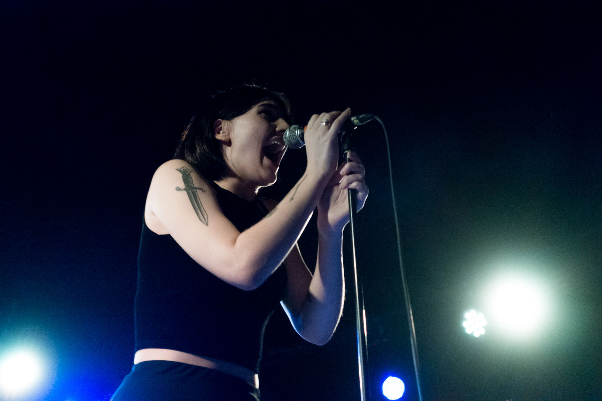 woman singing on stage at a concert during the day