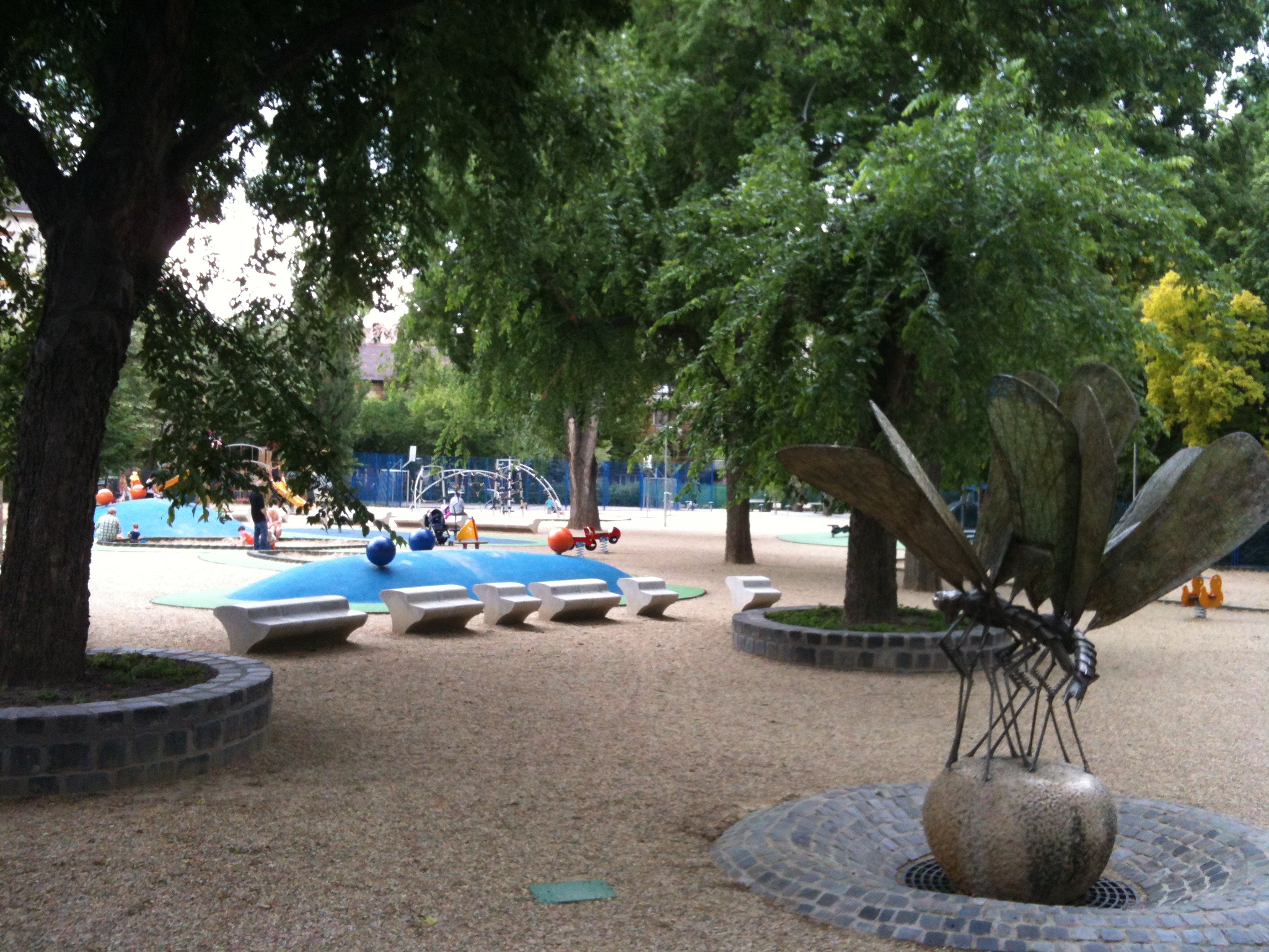 park with large sculptures and playground area with trees