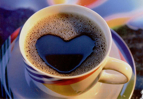 a heart cut out in coffee is displayed on a saucer