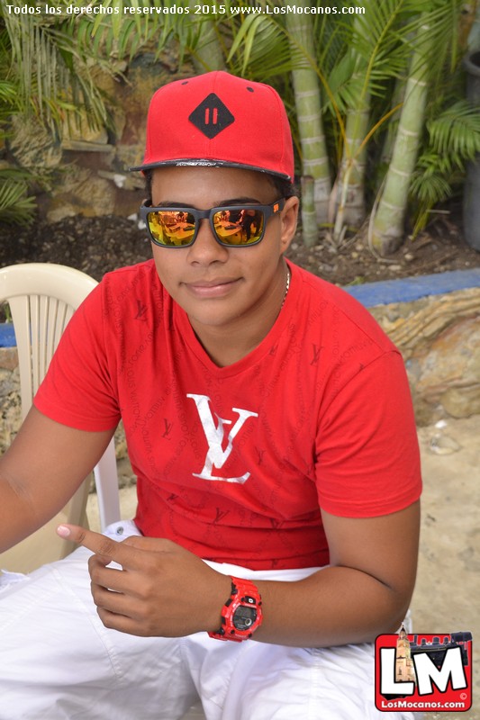 a person wearing sunglasses, a hat, and a red shirt sitting on a chair