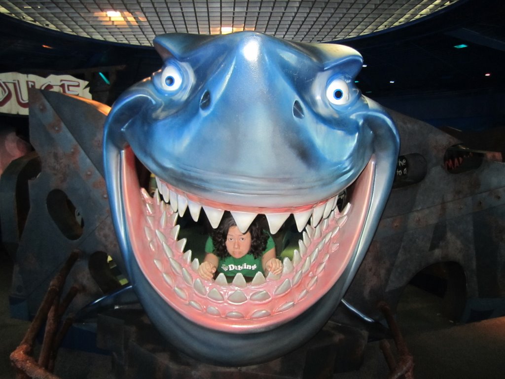 a large fish statue with open mouth in front of a crowd of people