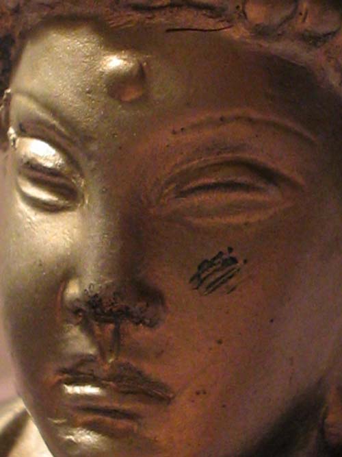 the face of a statue has a tiny, eye opening
