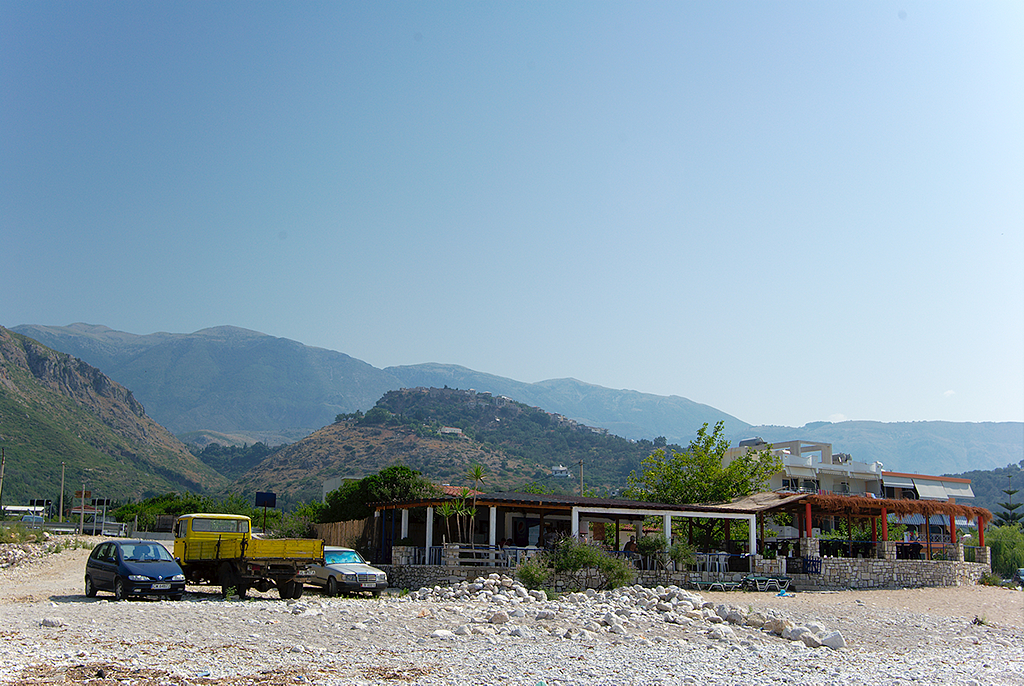 a car parked at a building with mountains in the background