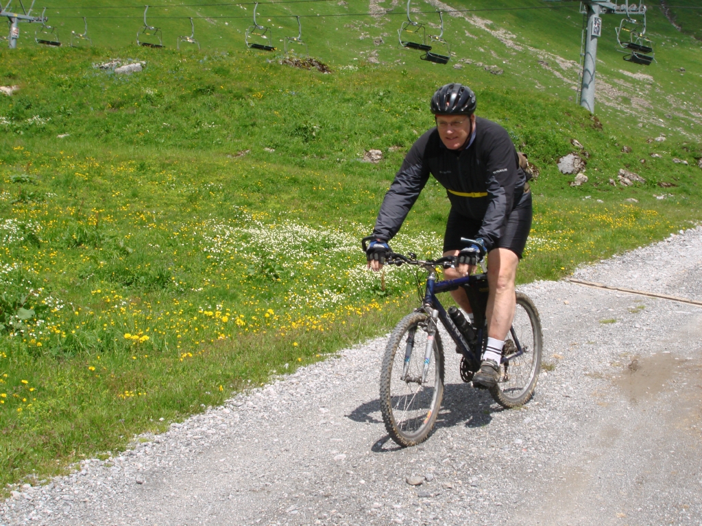 a man in black bicycle jacket riding on gravel road