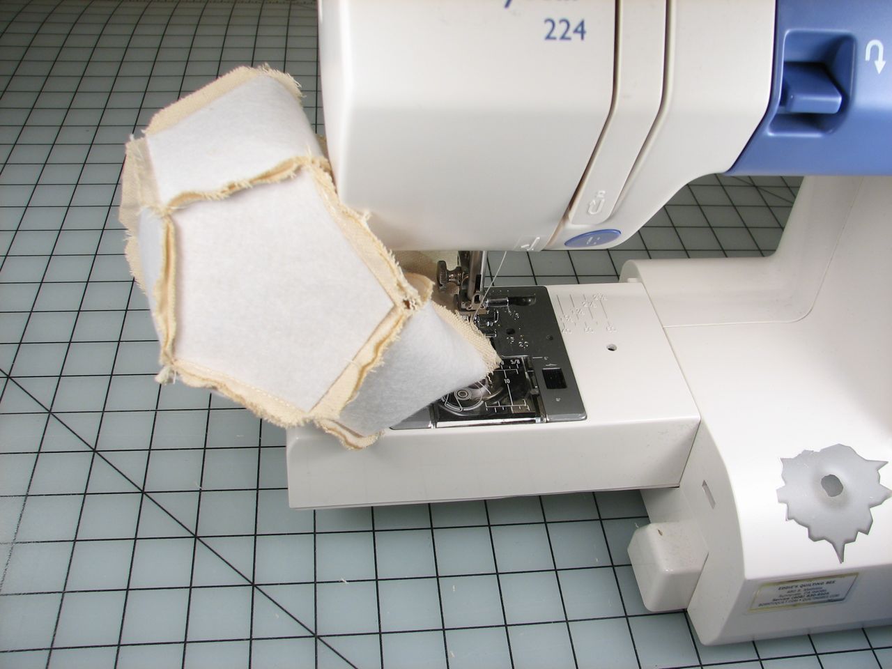 the fabric is being inserted under the sewing machine