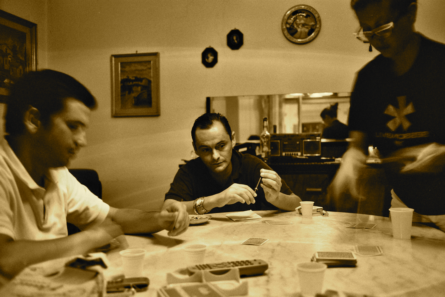 three men sit around a table and play a game