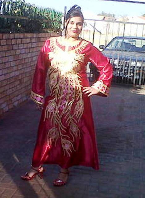an older asian woman in a long red dress poses for a picture