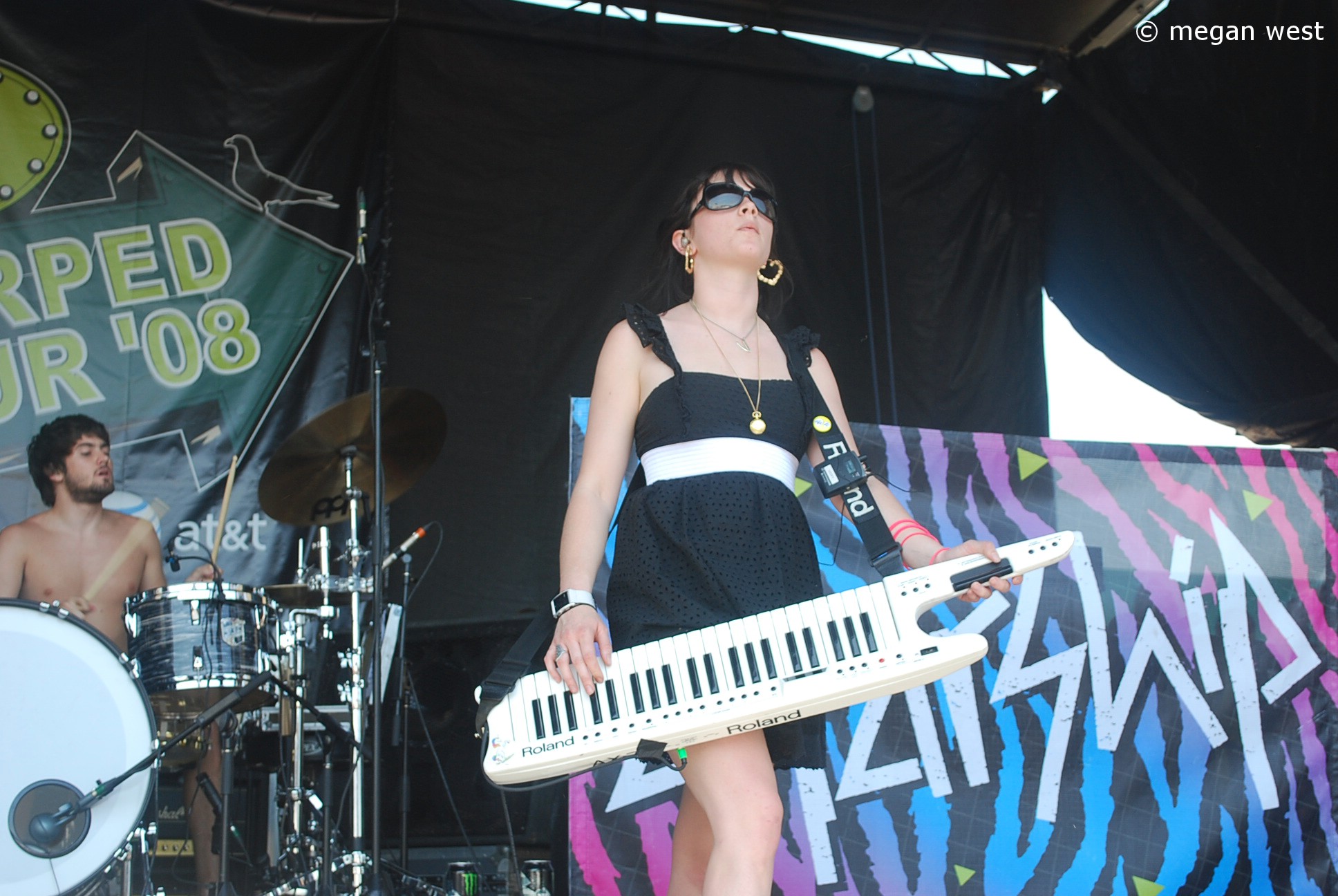a woman in sunglasses holding an electronic keyboard