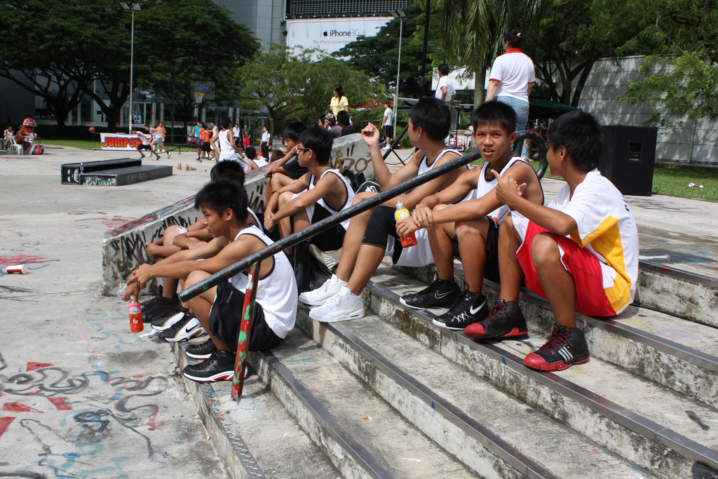 five young s sit on a cement slab