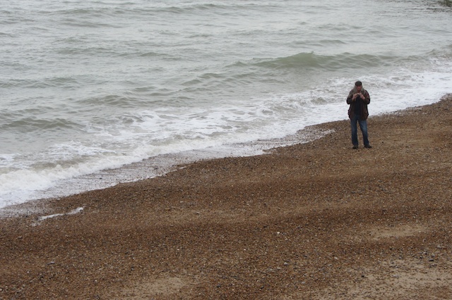 a person with a backpack looking at the ocean