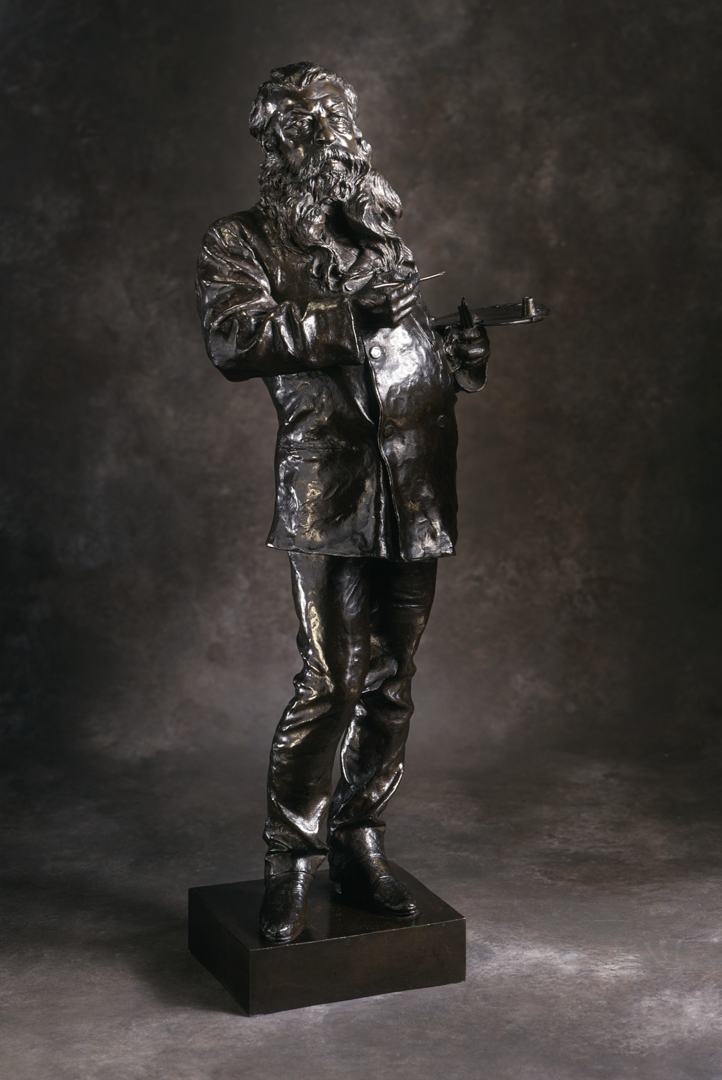 a large bronze statue with a black background