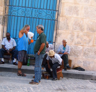 men sit on benches next to an entrance and a building