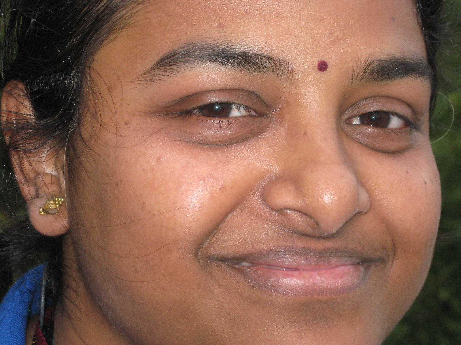 a woman with piercings is smiling at the camera