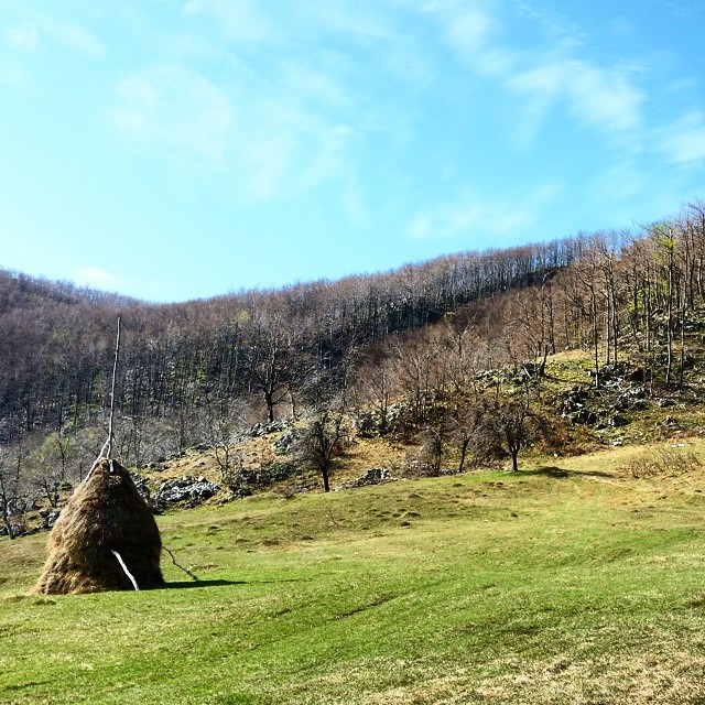 large hay bale near mountains in hilly area