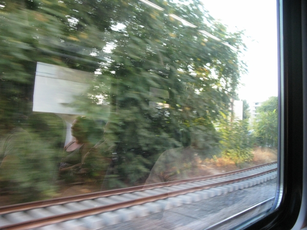 people are riding in the window of a moving train
