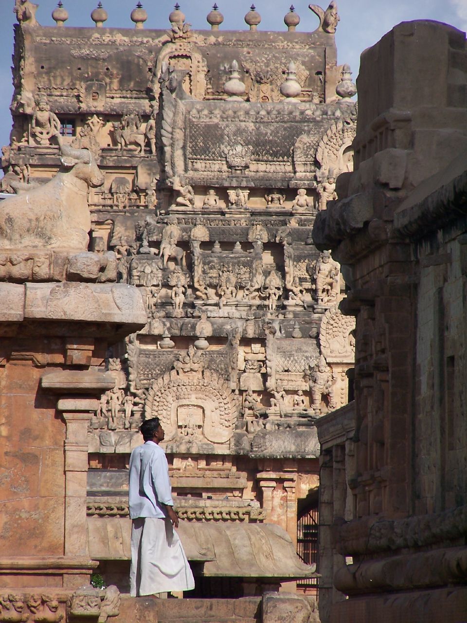 a man is standing on a balcony of an ancient temple