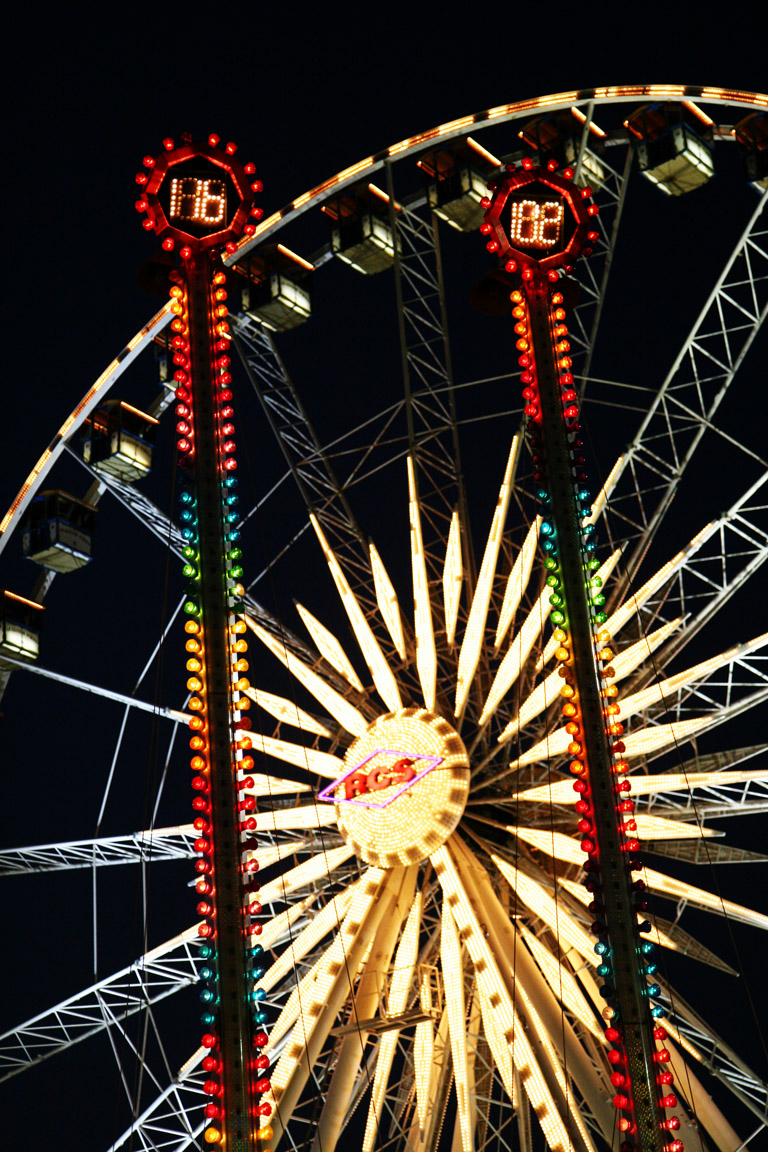 a large wheel lit up at night time