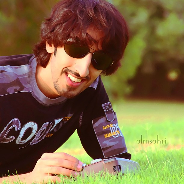 a man in sunglasses laying in a field on the ground