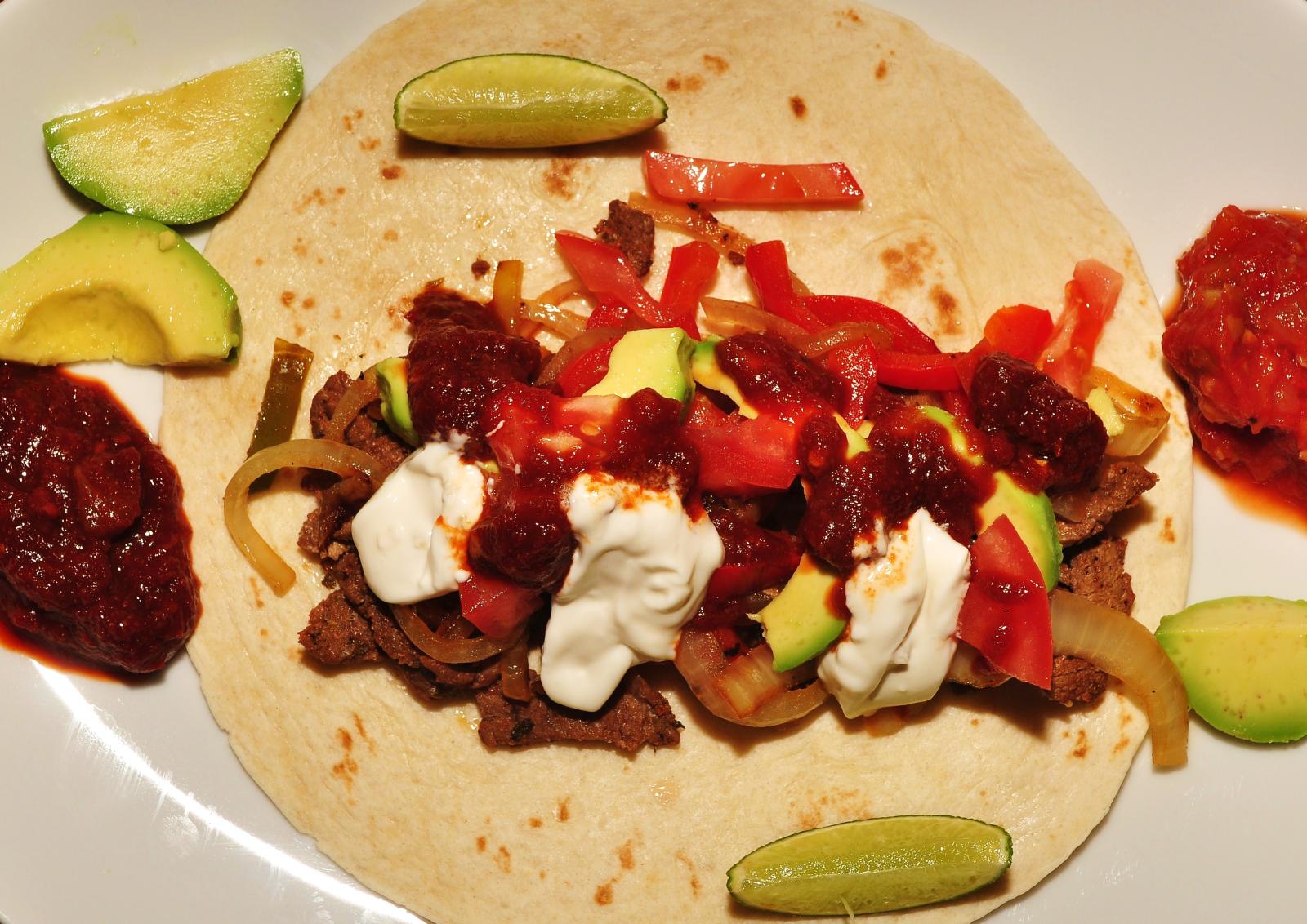 an unhealthy wrap, with tomatoes, onions, and sour cream