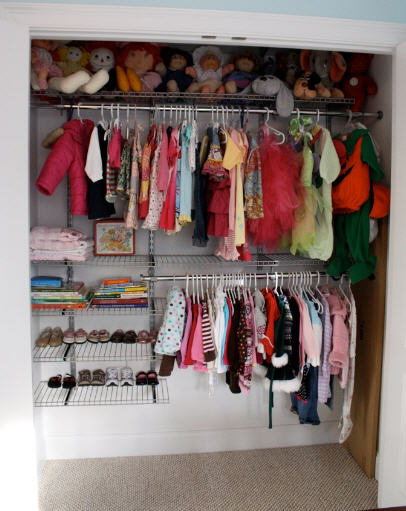 a walk - in closet has a bunch of babies'clothes on hangers