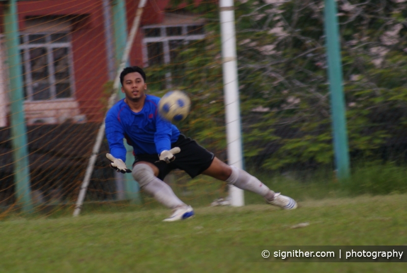 a man is playing soccer in front of the goalie