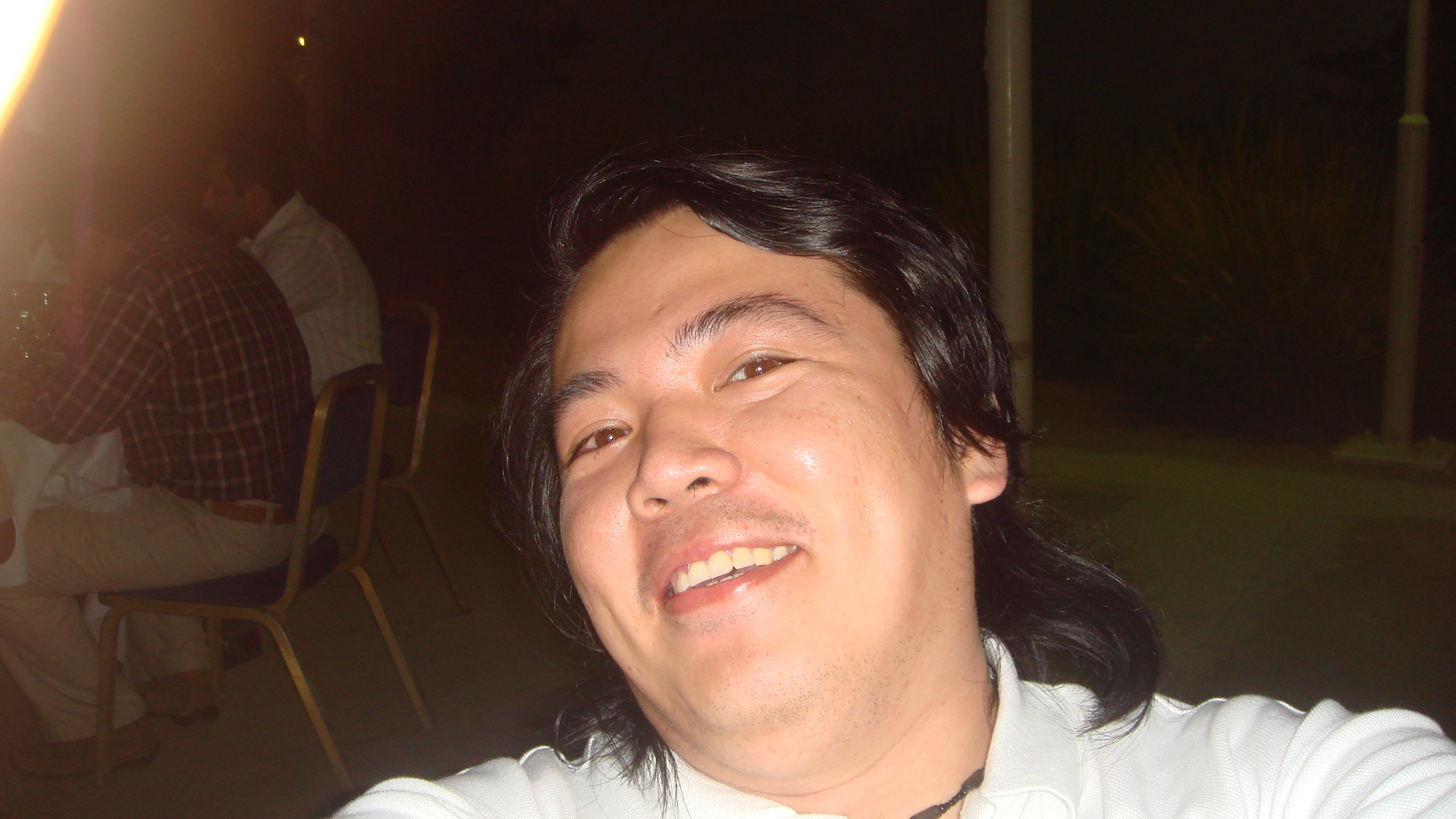 a man with black hair is smiling for the camera