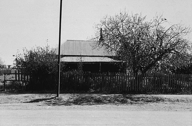 an old black and white pograph of a house in the middle of a rural area