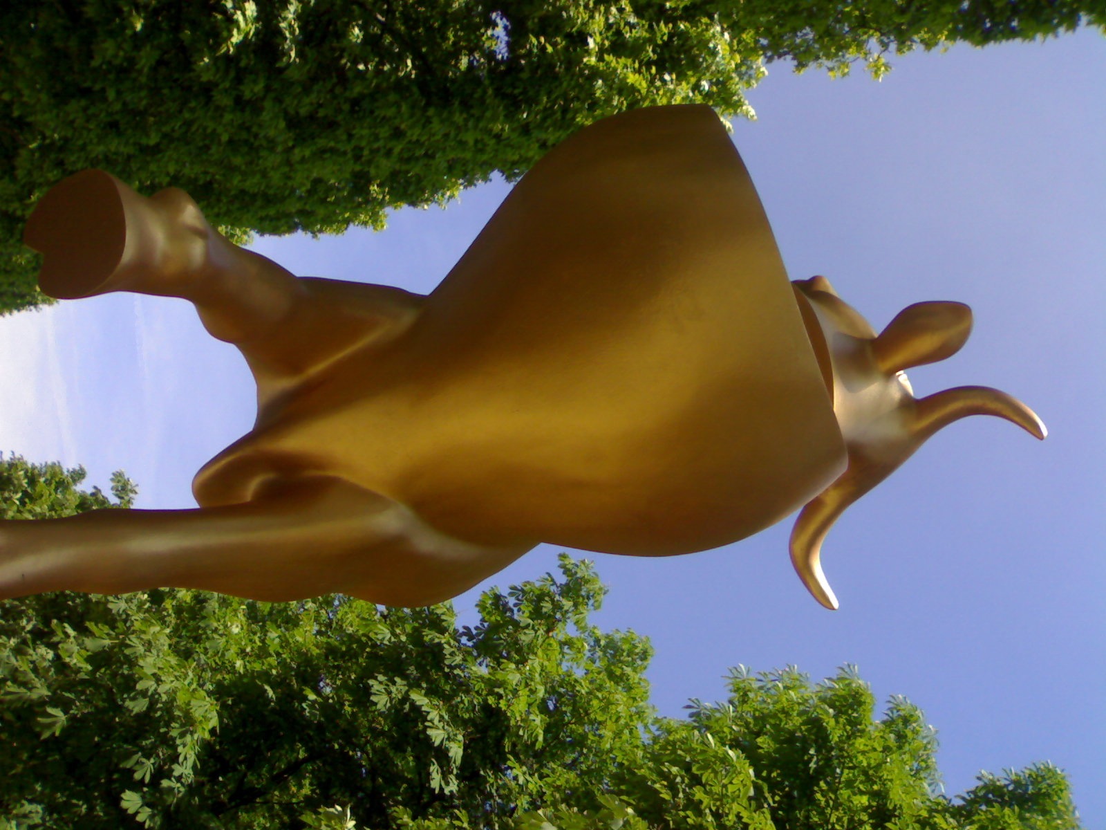 a statue of a cow that appears to be jumping up