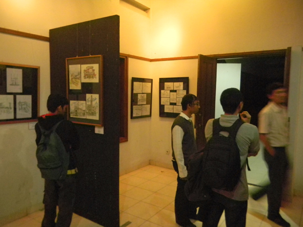 men standing in front of a door next to black doors