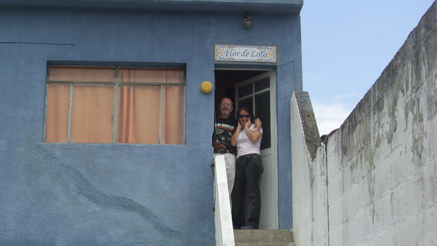 a couple of women standing at the bottom of stairs in front of a house