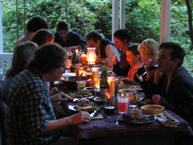 people sitting at table with food outdoors under glass walls
