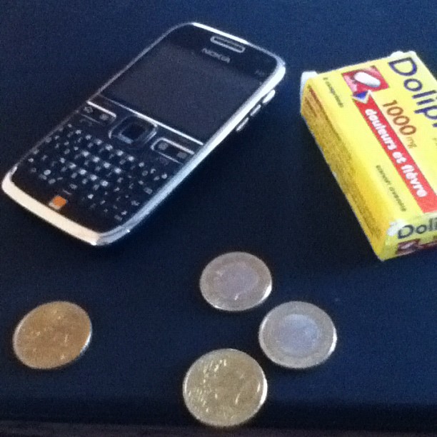 a cell phone, two packs of candy and some coins