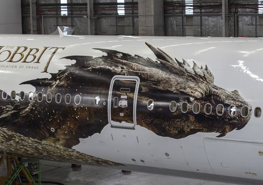 an airplane in a hangar with a dragon on the side